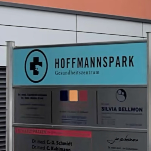 Schild des Gesundheitszentrums Hoffmannspark mit Übersicht der ansässigen Praxen.