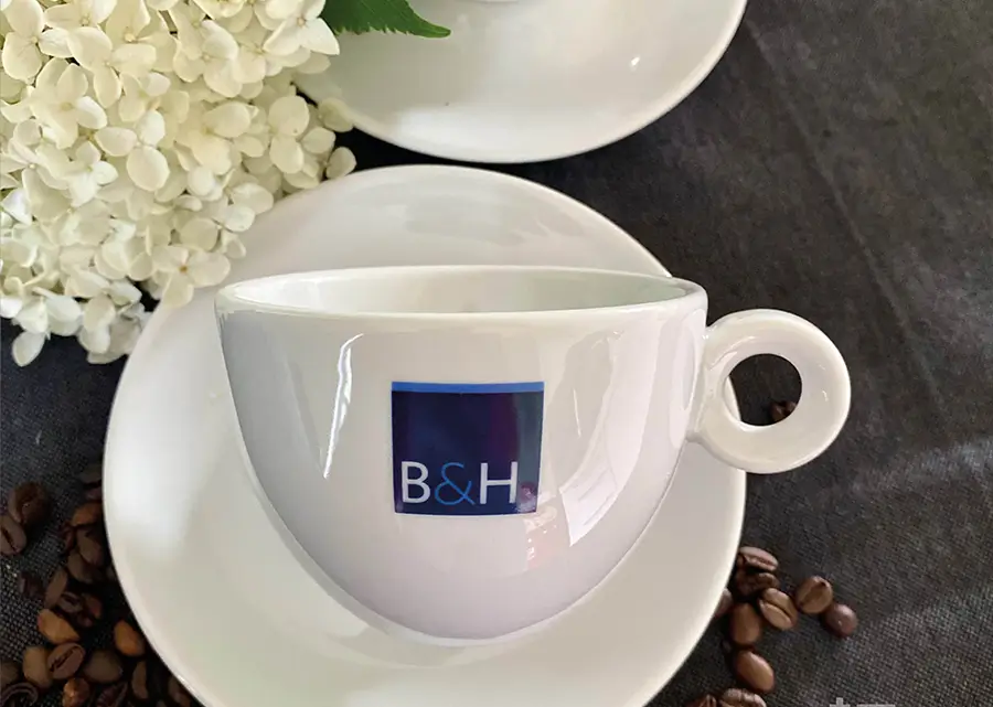 Hochwertige Tassen von B&H Steuerberatung mit schlichtem Logo-Design, ideal für den täglichen Gebrauch und als stilvolles Kundengeschenk.