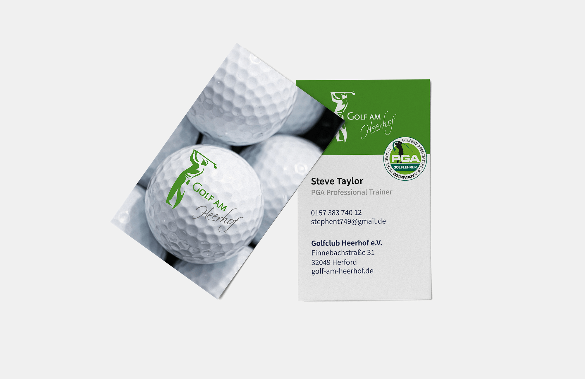 Zwei Visitenkarten des Golfclubs Heerhof e.V., eine mit einem Bild von Golfbällen und das Logo "Golf am Heerhof" in Grün, und die andere mit Kontaktdaten des PGA-Professional Trainers Steve Taylor. Die Karte zeigt das Logo des Golfclubs sowie ein PGA-Siegel.