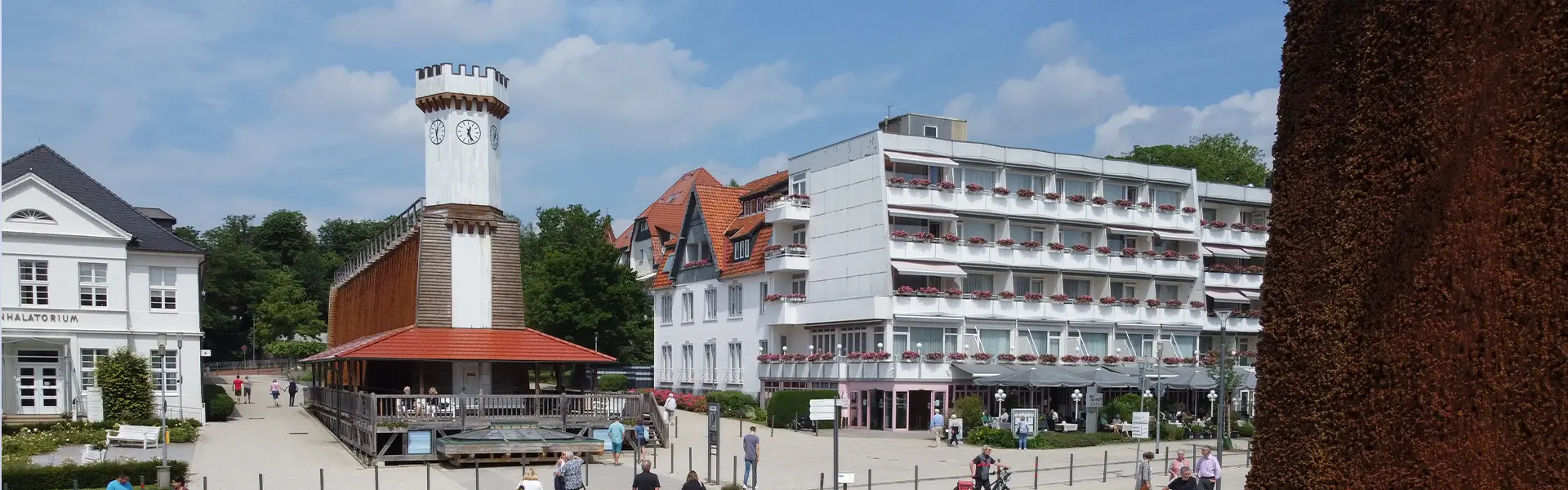 Das Kurpark Hotel in Bad Salzuflen, umgeben von einem malerischen Park, präsentiert eine moderne Architektur mit großen Fenstern und einer einladenden Fassade.